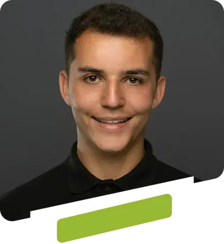 Smiling person with black shirt on grey background.